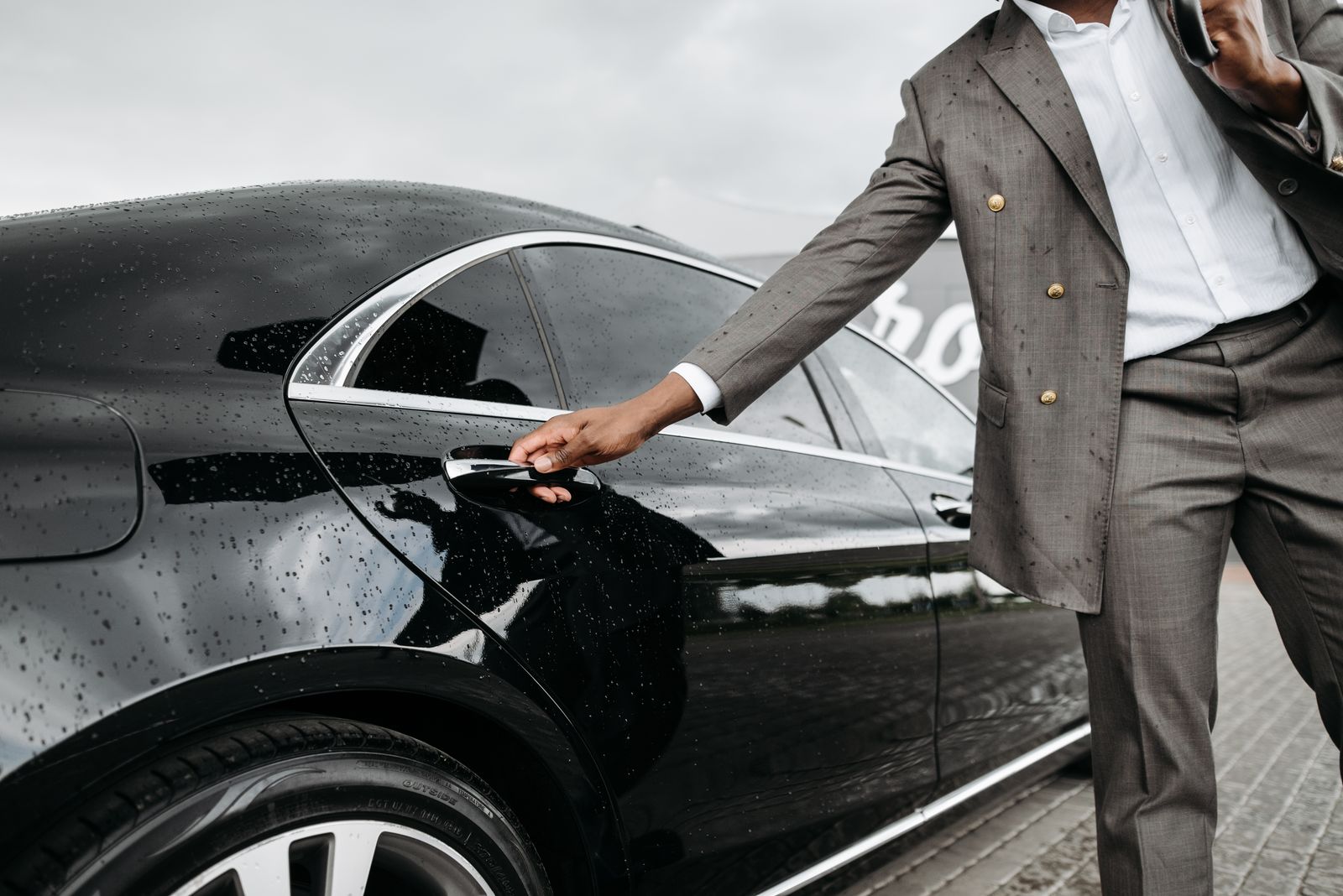 Chauffeur opening a car door for pickup and drop service